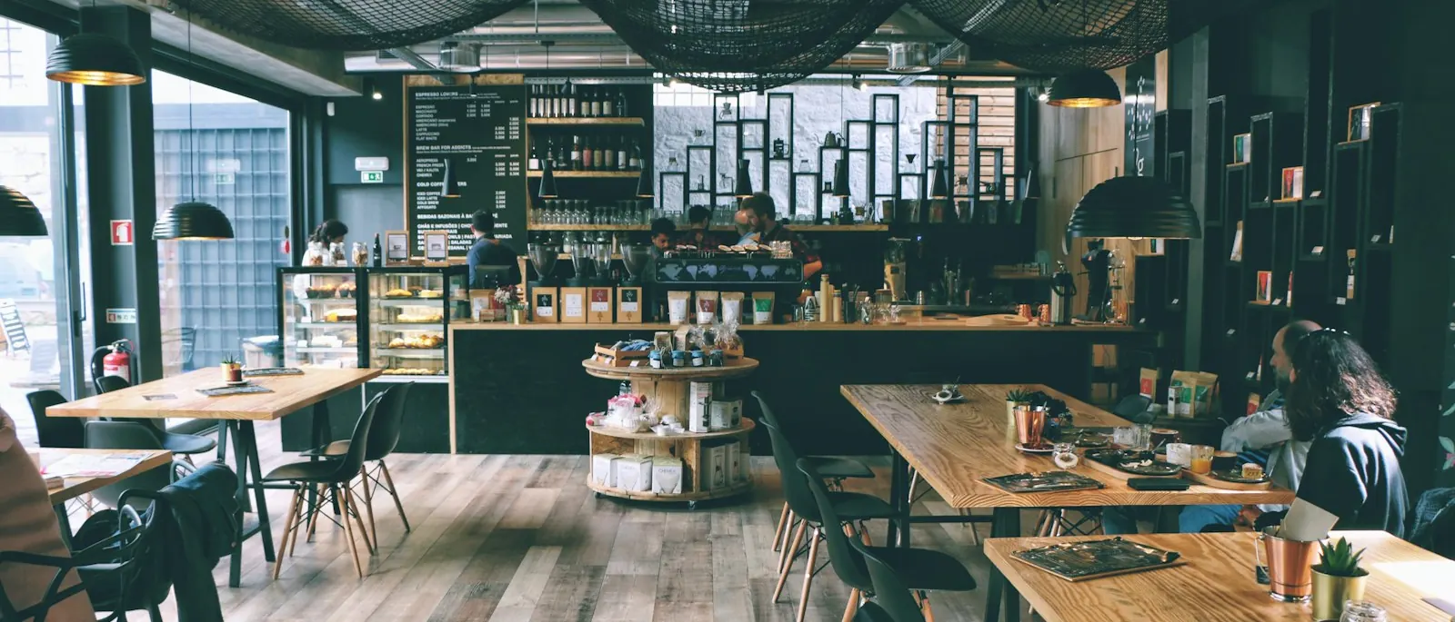 Inside the café: long tables, big windows, warm wood