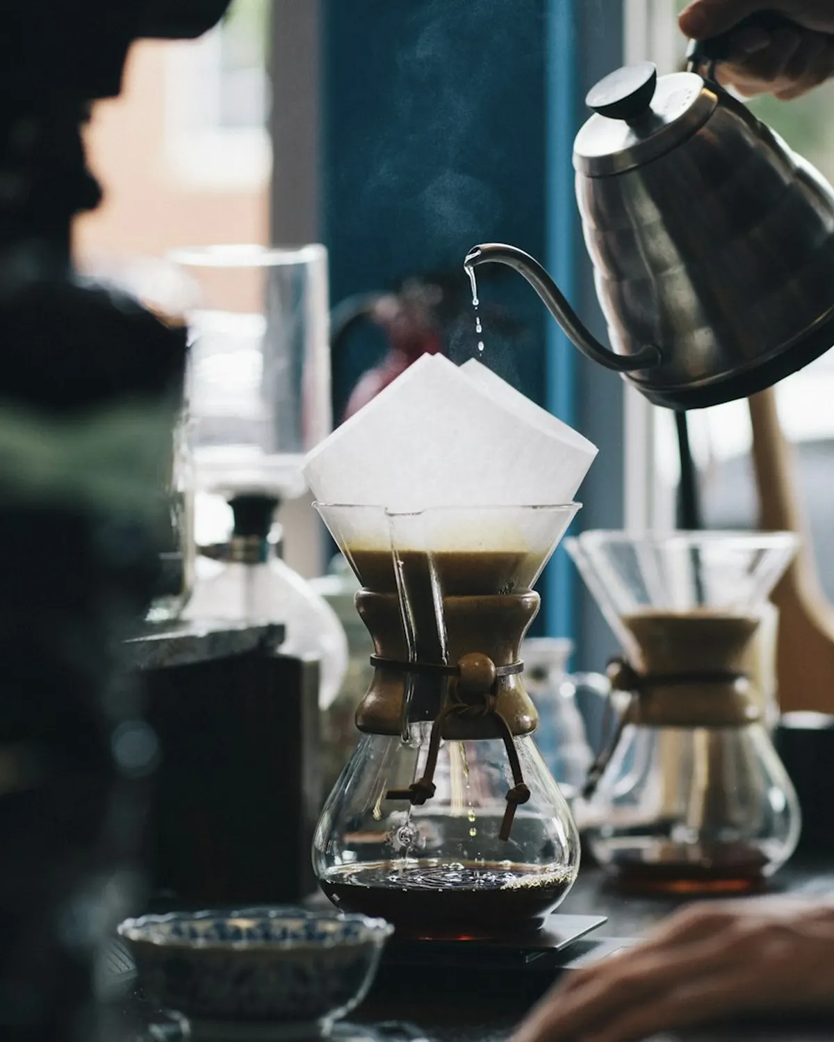 Barista pouring water over a pour-over filter
