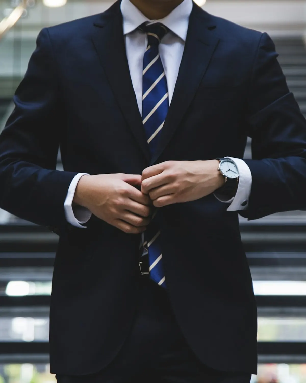 Attorney in a navy suit adjusting his jacket